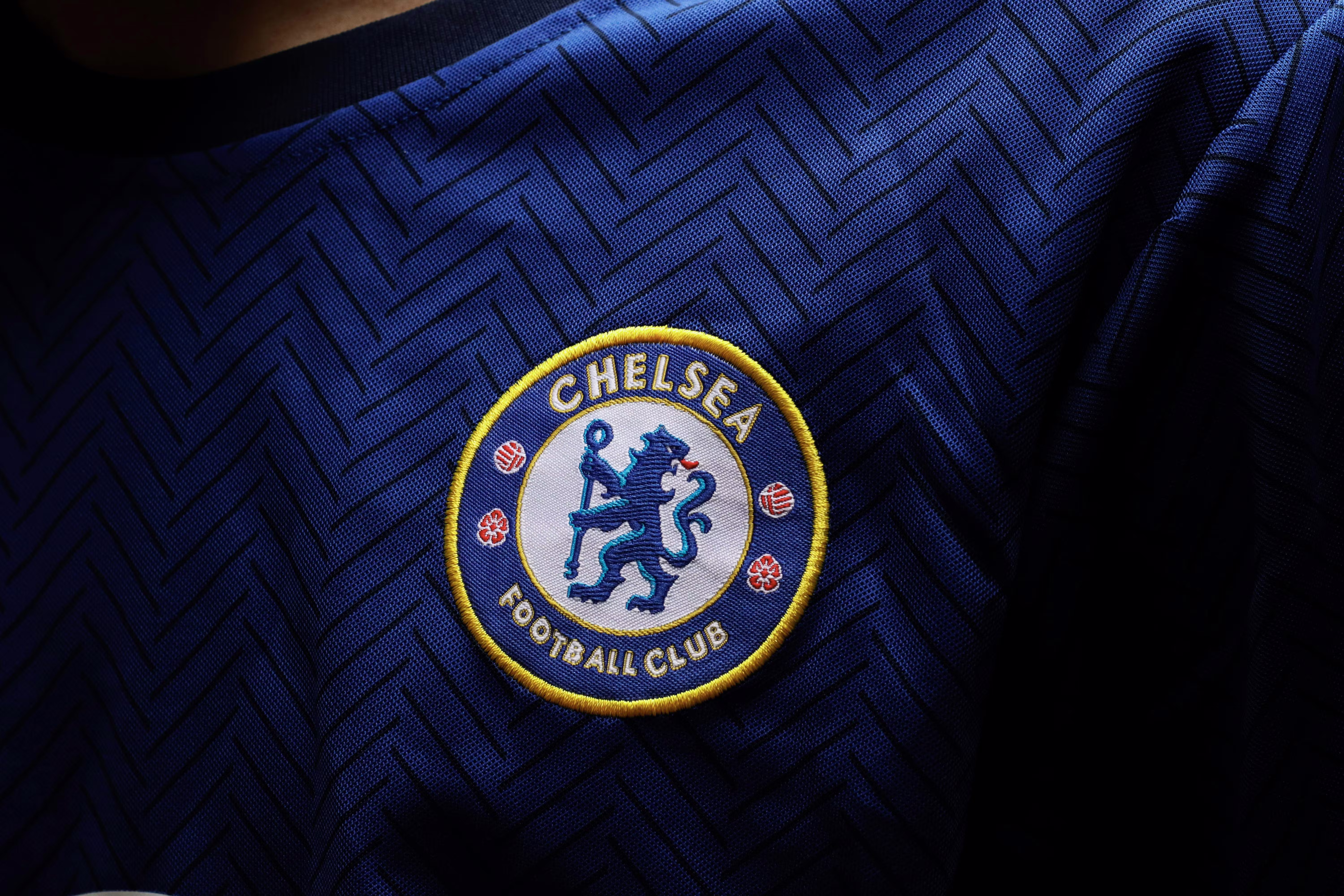 Gros plan sur une personne portant un maillot de football avec un écusson brodé